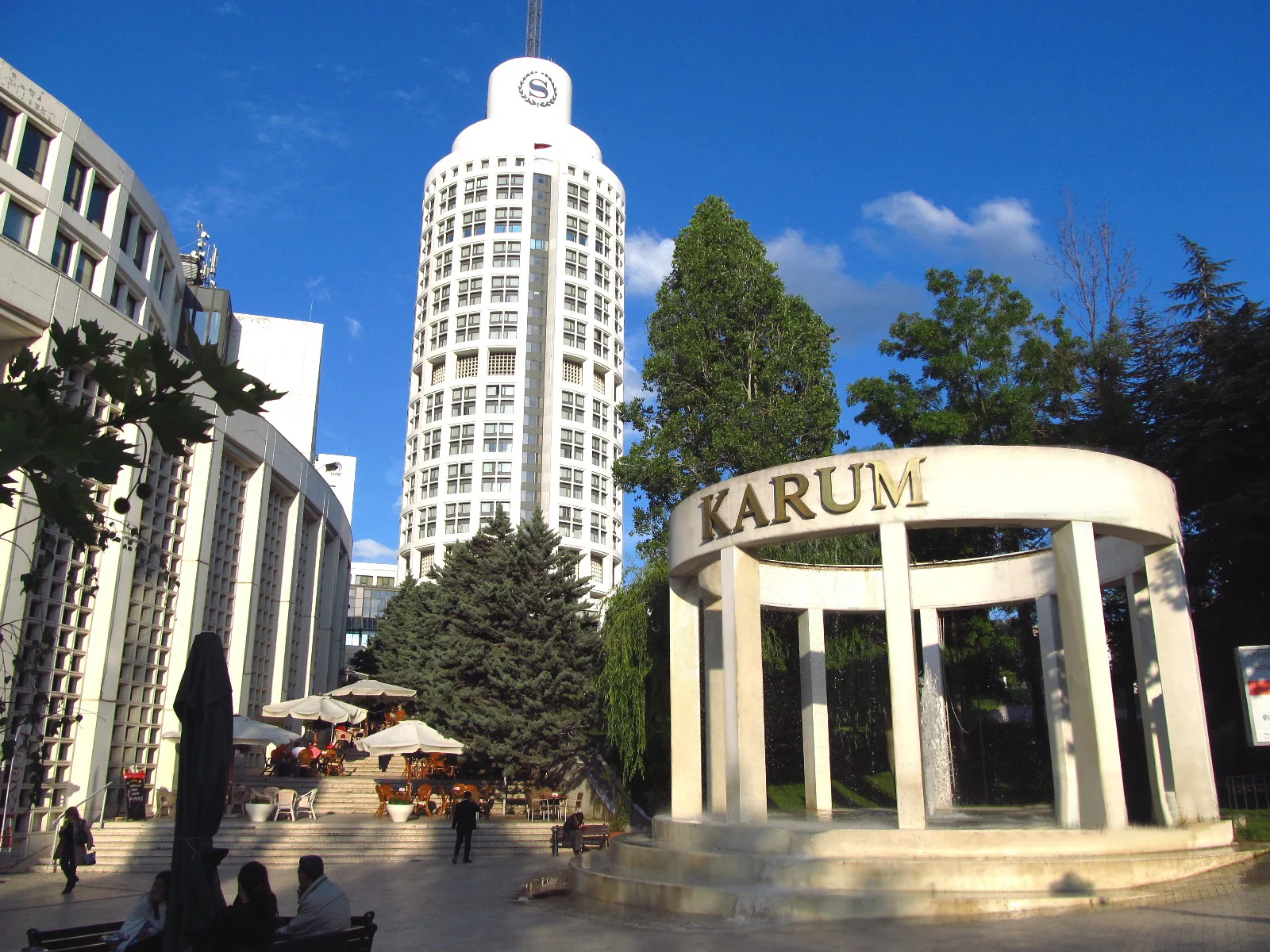 Ankara Karum business district with Sheraton Hotel iconic cylindrical tower, modern office buildings, executive Mercedes chauffeur vehicles, and professional business travelers